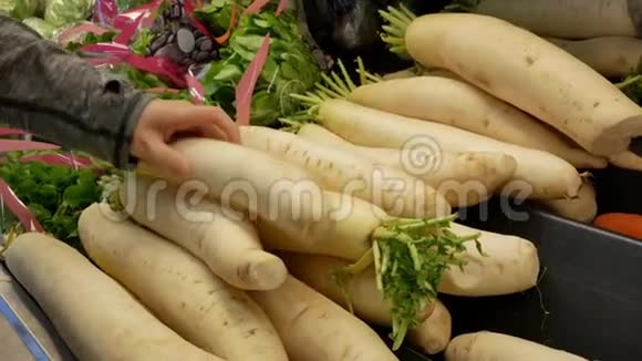 女人在超市里亲手采摘萝卜的动作视频的预览图