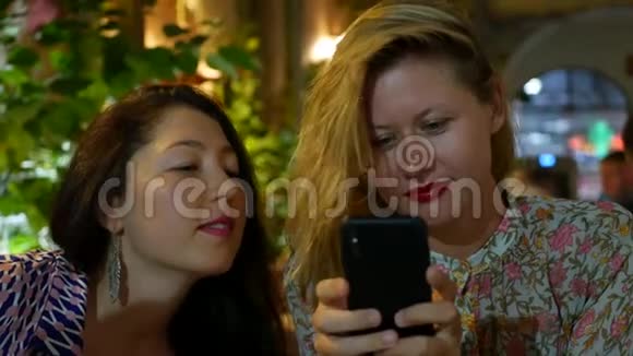 两个年轻的女人坐在餐馆里等着他们的菜被选中吃晚饭有很多朋友视频的预览图
