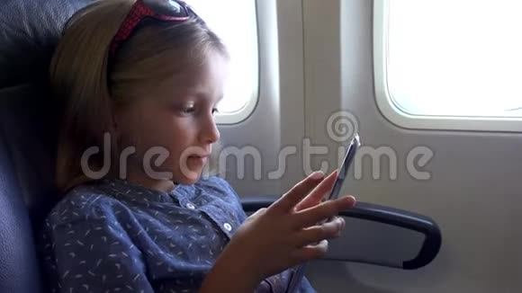 儿童在飞机上玩平板电脑小女孩使用智能手机4K肖像视频的预览图