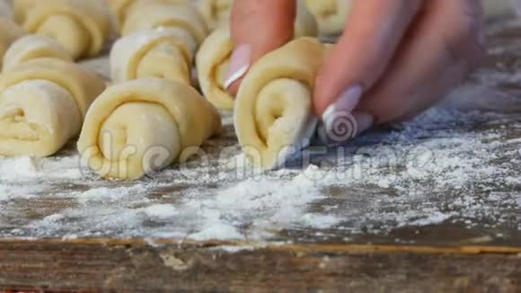 一排生牛角面包自制甜点果酱家里厨房的面团女性手拿一个羊角面包视频的预览图