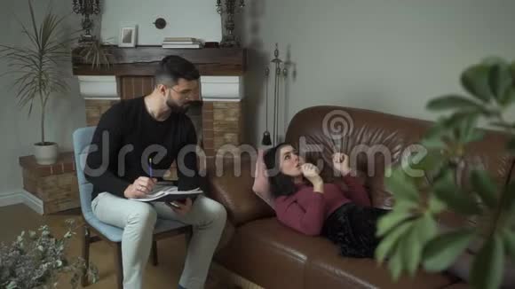 沮丧的白种人女人躺在沙发上情绪化地谈论她的问题专业男性心理学家视频的预览图