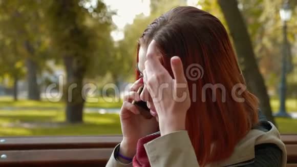 有着狐臭头发的女孩坐在长凳上和一家网上商店的经理通电话在网上下订单视频的预览图