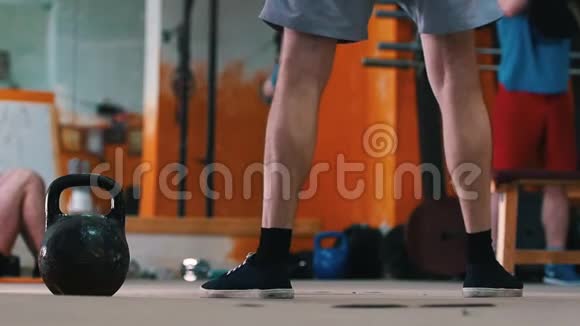 体育训练在健身房里做运动的男人一个蹲在前台的男人手里拿着体重视频的预览图