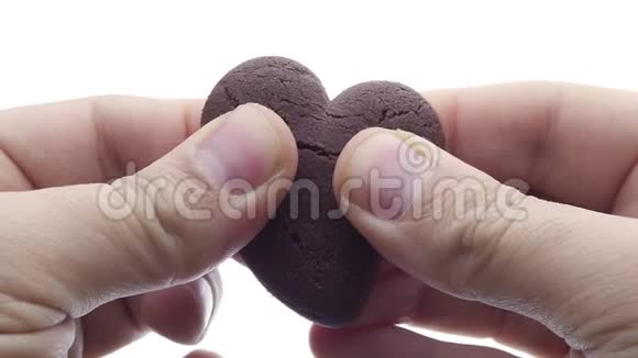 手打破巧克力心形饼干或饼干特写慢动作视频的预览图