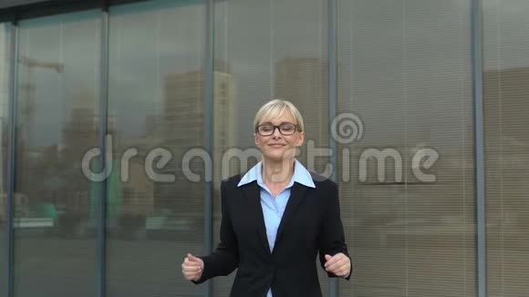 成功的商务小姐在户外办公大楼做赢家手势自由视频的预览图