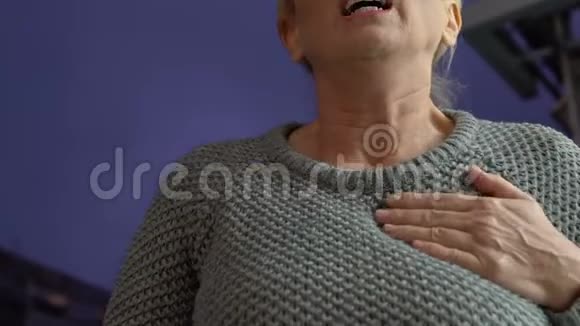 老妇人在晚上的街道上感到胸部疼痛有心脏病发作的危险健康视频的预览图