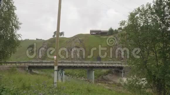 在乌拉尔村的Kyn河和桥的景色一块严重的乌拉尔性质视频的预览图