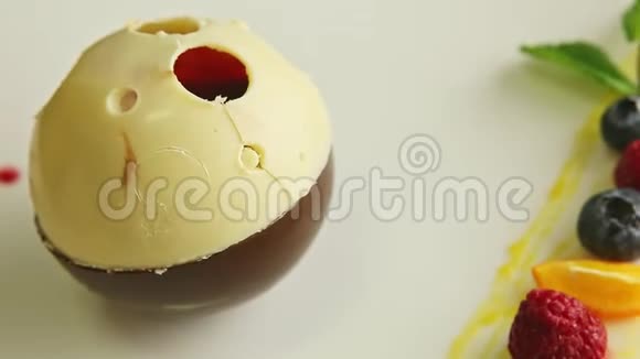 装饰精美的巧克力球形甜点在盘子上旋转视频的预览图