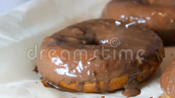 大的多色鲜炸面圈排在一张桌子上一个美丽的甜甜圈和巧克力糖衣洒在视频的预览图