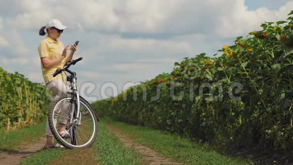 骑自行车的女人在大自然中捕捉到电话信号视频的预览图