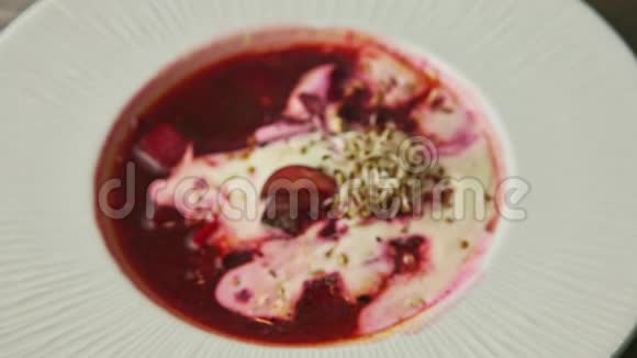 顶部特写传统的红罗宋汤用酸奶油和麦芽装饰视频的预览图