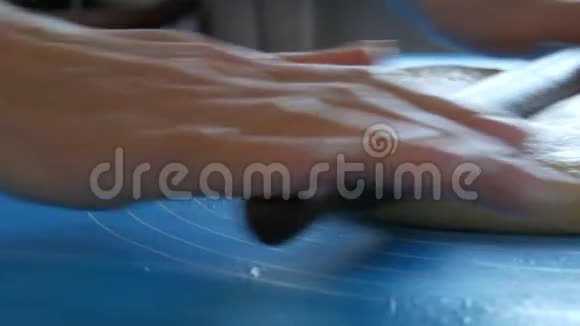 女性的手用擀面杖在一个特殊的硅胶垫上擀出面团用来捏面团现代技术视频的预览图