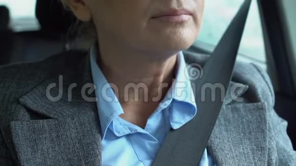 成熟女商人的特写镜头颈部疼痛坐在司机的位置视频的预览图