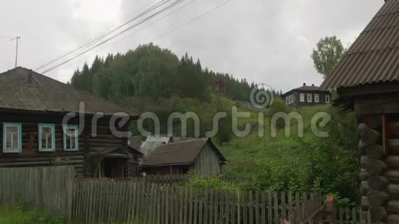 古老的俄罗斯村庄古老的木屋和绿色多汁的草地视频的预览图