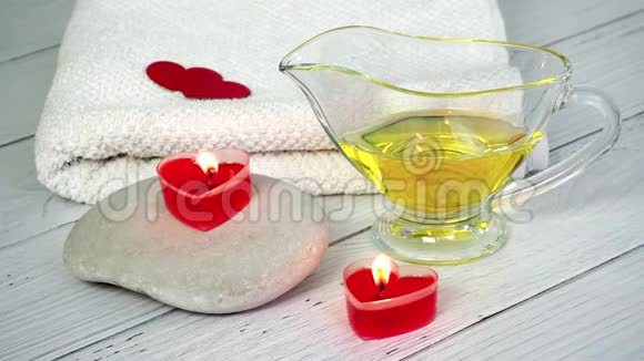 情人节水疗概念将红色心形蜡烛石头按摩油和一条白色毛巾放在上面视频的预览图