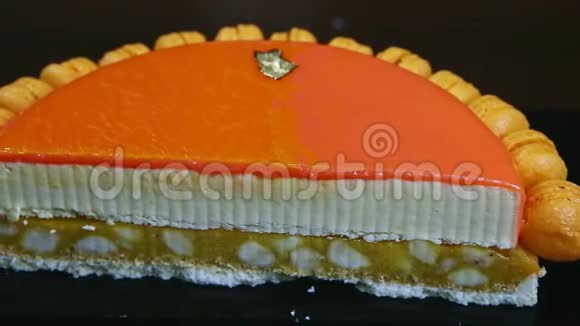 一半芝士蛋糕上装饰着橙色镜面釉的特写全景视频的预览图