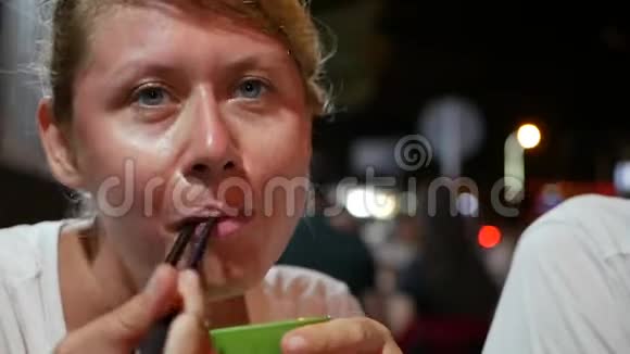 女人在亚洲夜市用筷子吃鱼和米粉关门视频的预览图