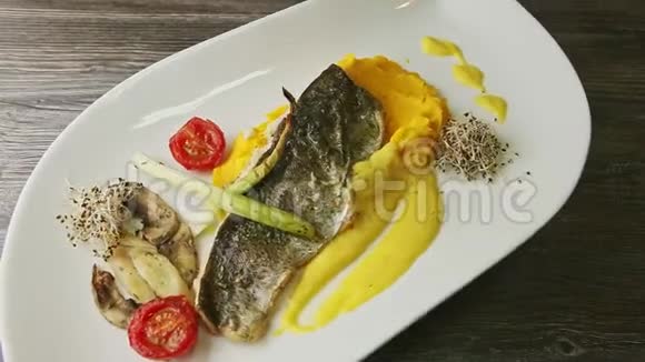 美味的烤海鱼片放在土豆泥上蔬菜切片放在盘子上视频的预览图