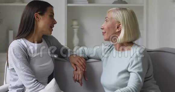 了解年轻的成年女儿和年长的妈妈在家聊天视频的预览图