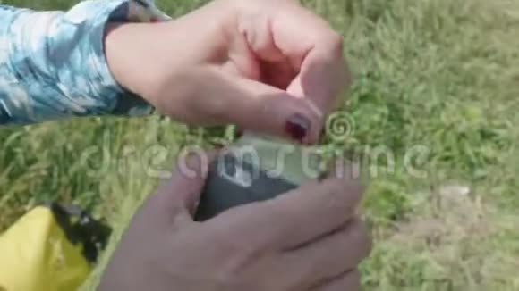 近距离观看女人的手试图把避孕套放在智能手机上使它防水视频的预览图