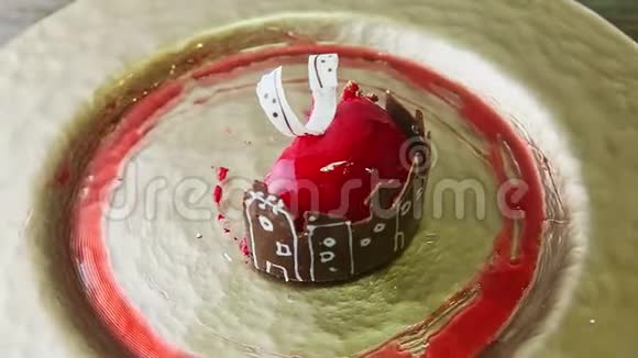 加奶油慕斯甜点的特写一半切片巧克力城堡在盘子上旋转视频的预览图