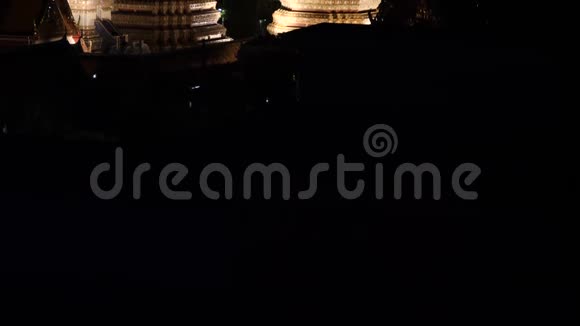 晚上在泰国曼谷的4KWatPho寺惊涛骇浪穿过灯火通明的寺庙塔和宝塔视频的预览图