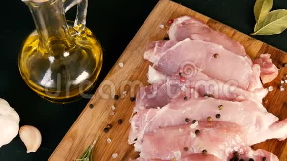 新鲜的猪肉培根肉片在木制厨房板上以乡村风格大蒜迷迭香枝粗盐视频的预览图