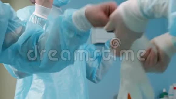 医务助理穿着蓝色手术服戴上乳胶手套准备手术视频的预览图