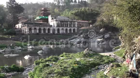 鸟儿飞过污染的河流背景是印度教寺庙视频的预览图