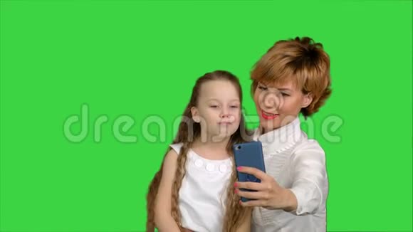 可爱的家庭母亲和孩子女儿在绿色屏幕上自拍智能手机照片Chroma键视频的预览图