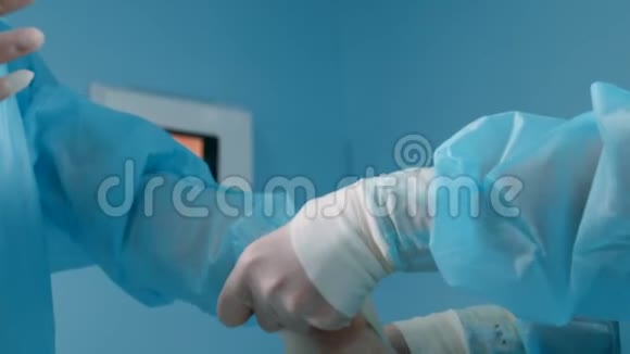 医务助理穿着蓝色手术服戴上乳胶手套准备手术视频的预览图