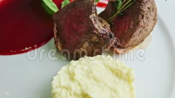 特写多汁的烤肉和土豆泥在白色盘子上旋转视频的预览图