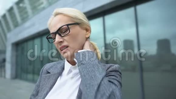 商业女性戴眼镜按摩颈部感觉痉挛健康视频的预览图