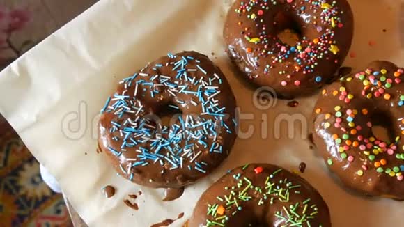 新鲜可口的圆形甜甜圈有多种颜色的巧克力糖衣粉色蓝色白色橙色绿色和各种装饰视频的预览图