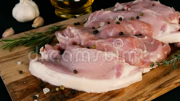 新鲜的猪肉培根肉片在木制厨房板上以乡村风格大蒜迷迭香枝粗盐视频的预览图