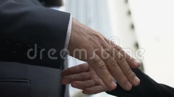 男公司负责人与商业伙伴在户外握手合作视频的预览图