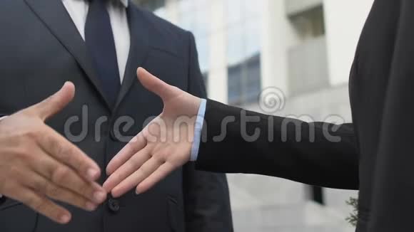 男女商业伙伴在户外握手成功成交特写视频的预览图