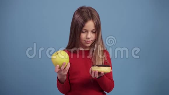 艰难的决定可爱的女孩选择在一个巧克力甜甜圈与一个绿色的新鲜苹果之间视频的预览图