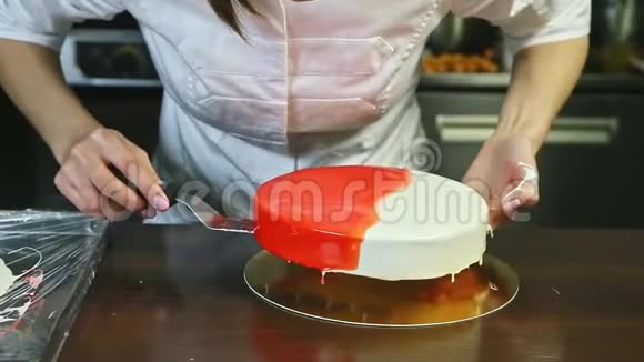 糖果师将整个釉面圆饼放在金盘上视频的预览图