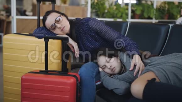 有十几岁女儿的女人睡在机场休息室等待注册开始视频的预览图