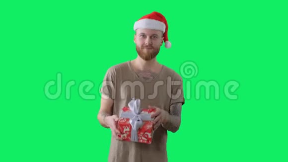 身穿绿色t恤戴着红色圣诞帽长着胡须纹身的年轻帅哥带着彩色钥匙跳舞视频的预览图