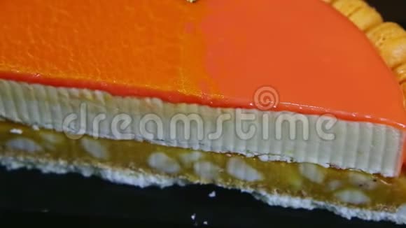 一半芝士蛋糕上装饰着橙色镜面釉的特写全景视频的预览图