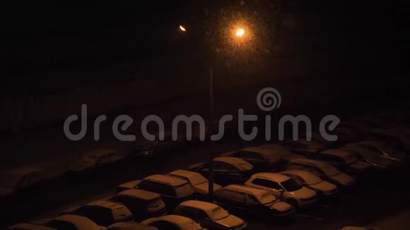 傍晚时分在一个灯笼下的停车场下雪视频的预览图