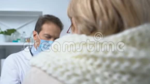 老人戴围巾咳嗽医生在病历上写症状视频的预览图