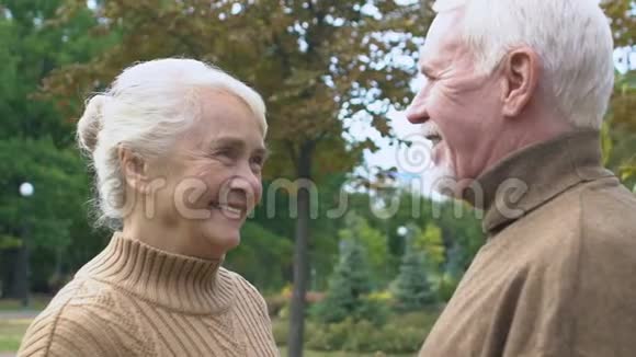 快乐的成熟夫妻微笑着在公园里度过时光快乐的时刻慢镜头视频的预览图