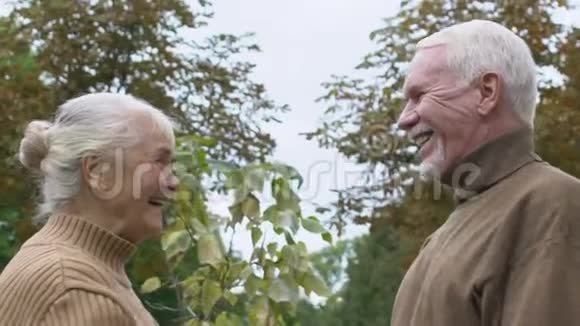 开朗的老年女性看着爱情的男人户外老年夫妇的联系视频的预览图
