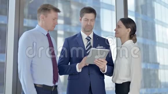 成功的执行商界人士使用平板电脑并在会议室庆祝视频的预览图
