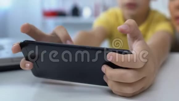 年轻母亲在玩智能手机的电子游戏中支持小儿子视频的预览图