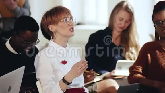 快乐的年轻白种人企业家女企业家在现代光多样性办公室会议研讨会上提问视频的预览图