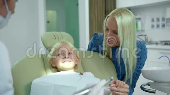 妈妈牵着女儿的手牙医解释视频的预览图